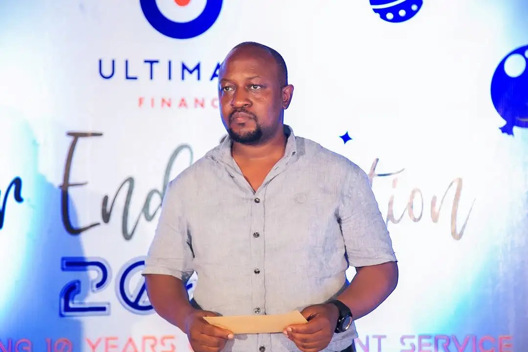 A man holding a certificate on stage in front of the Year End Function 2023 backdrop
