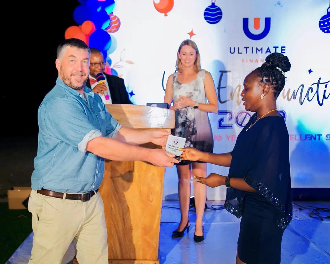 A man handing an award across a lectern to a colleague at the evening function